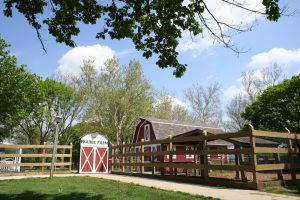 Farm themed children's petting zoo with red barn and wooden fences call Prairie Farm.