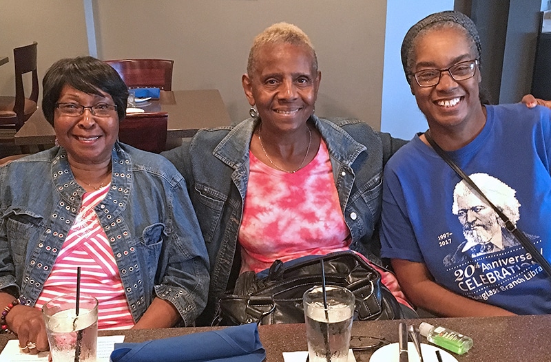 3 older ladies sitting at a table smiling