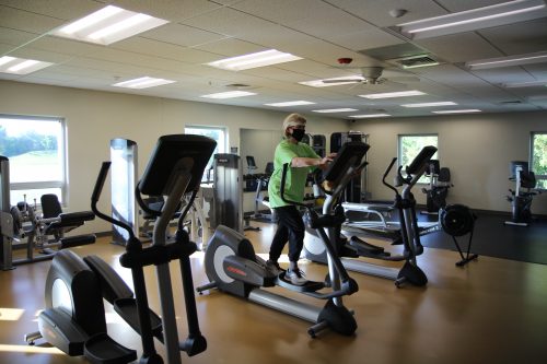 A person working out on an elliptical machine in a cardio room.