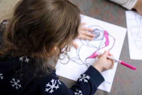 A child coloring on a coloring page.