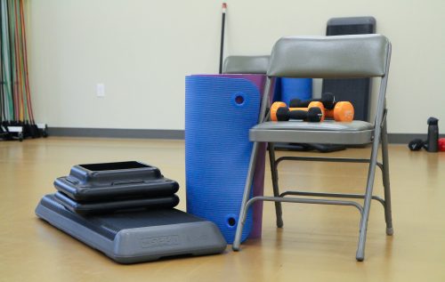 Gym equipment including a mat, risers, and hand weights.