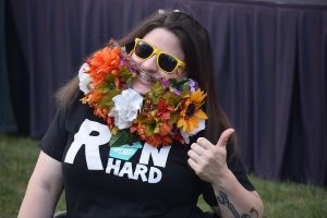 Woman wearing a large crafted beard from flowers.