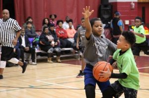Youth basketball players in a heated game at Douglass Community Center