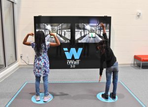 Two children playing with virtual game at Martens Center.