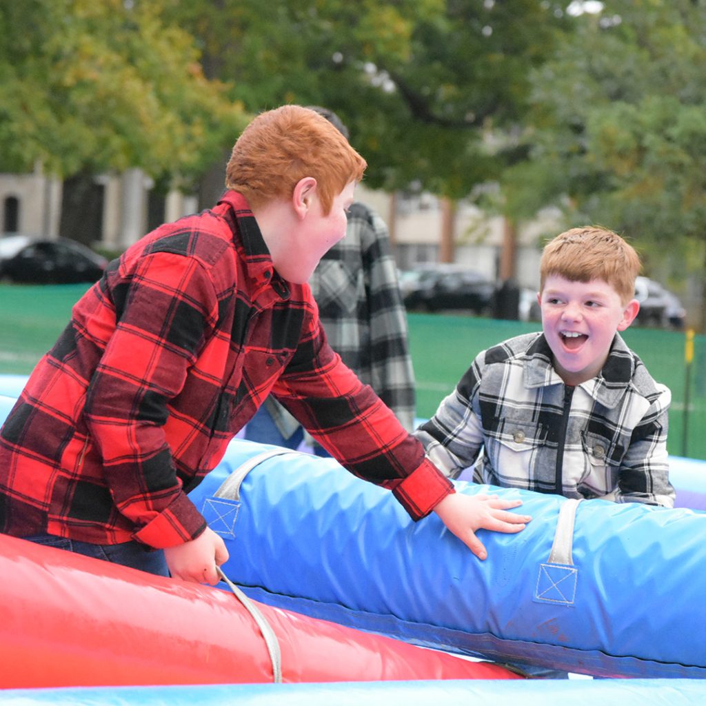 Two kids playing on inflatables at Flannel Fest.