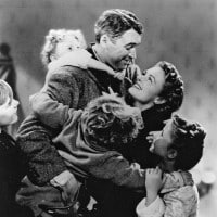 In black and white, a man and woman embrace, and four children gather around them