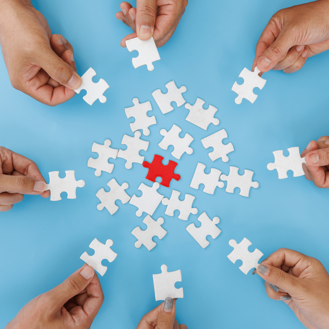 7 hands holding puzzle pieces