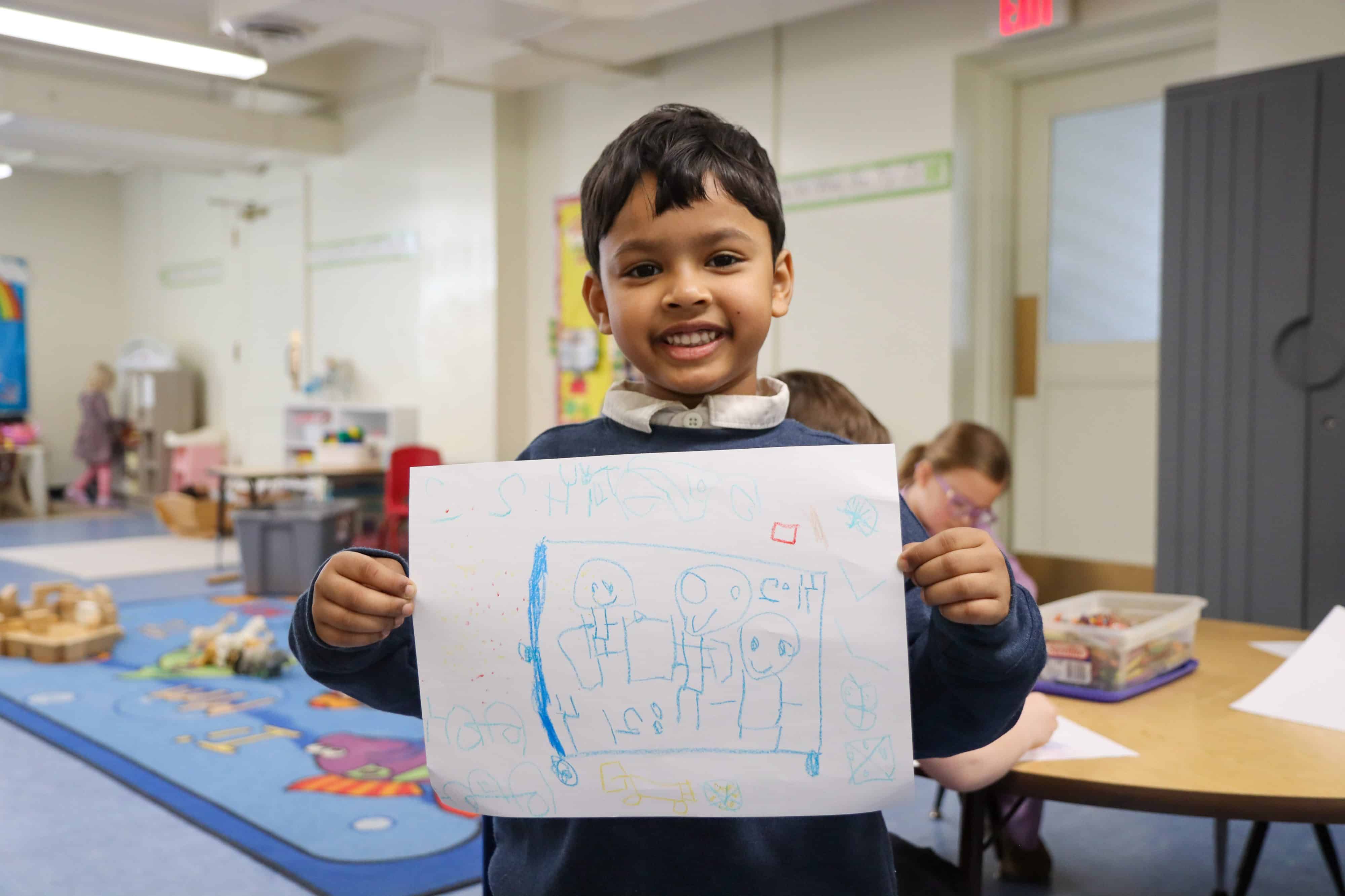 kid showing drawing of bus 