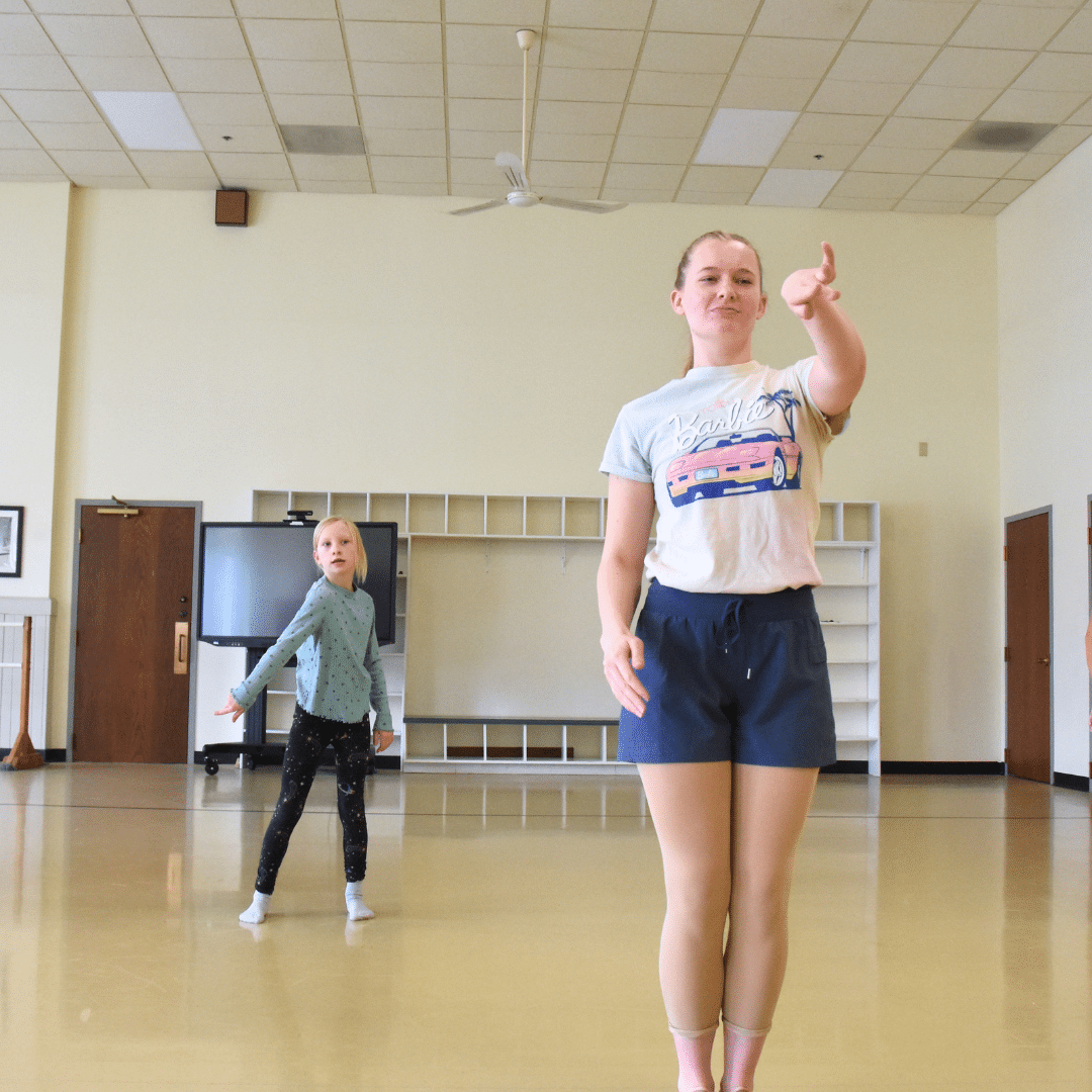 An adult and a child dance in a studio.